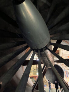 A view from behind the fan that drove the wind tunnel, two people stand between the blades